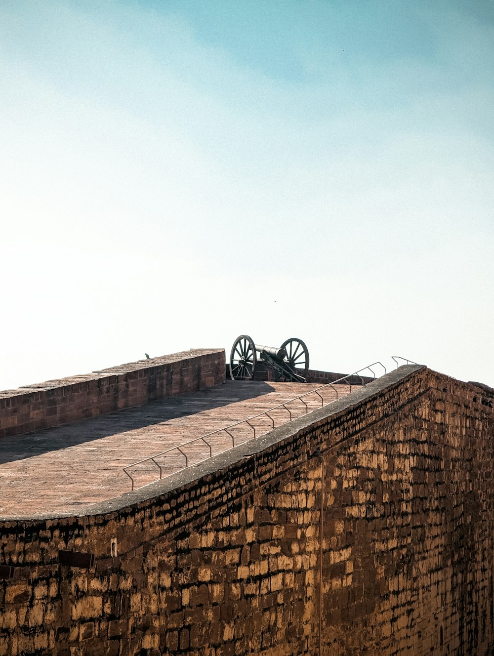 Un edificio de ladrillo con una bicicleta en la parte superior