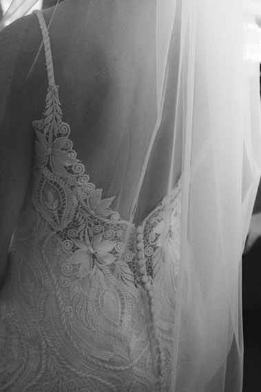Close-up of delicate bridal lace with intricate floral patterns in soft white.