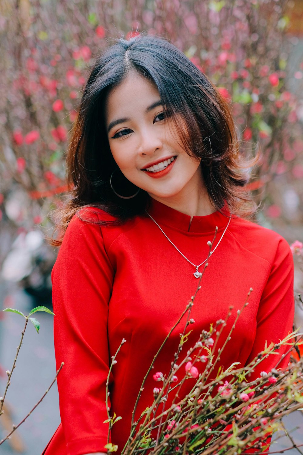 a woman smiling in front of a flowering tree