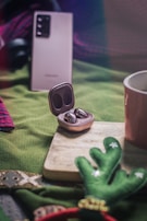 A pair of wireless earbuds nestled in a gift box wrapped with a subtle holiday ribbon.