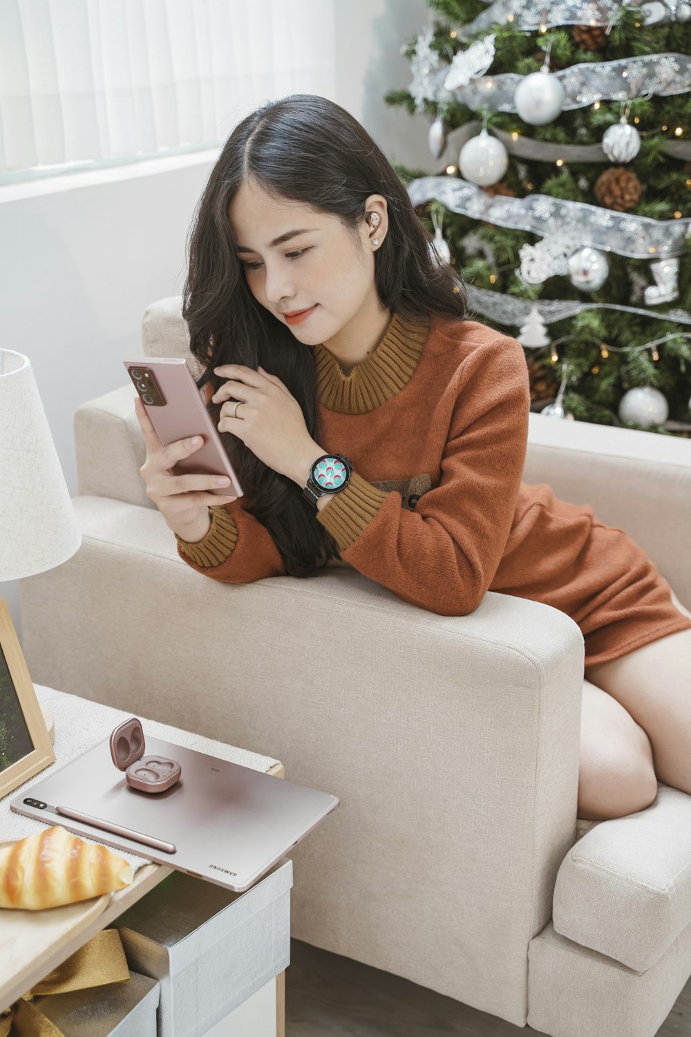 a woman sitting on a couch reading a book