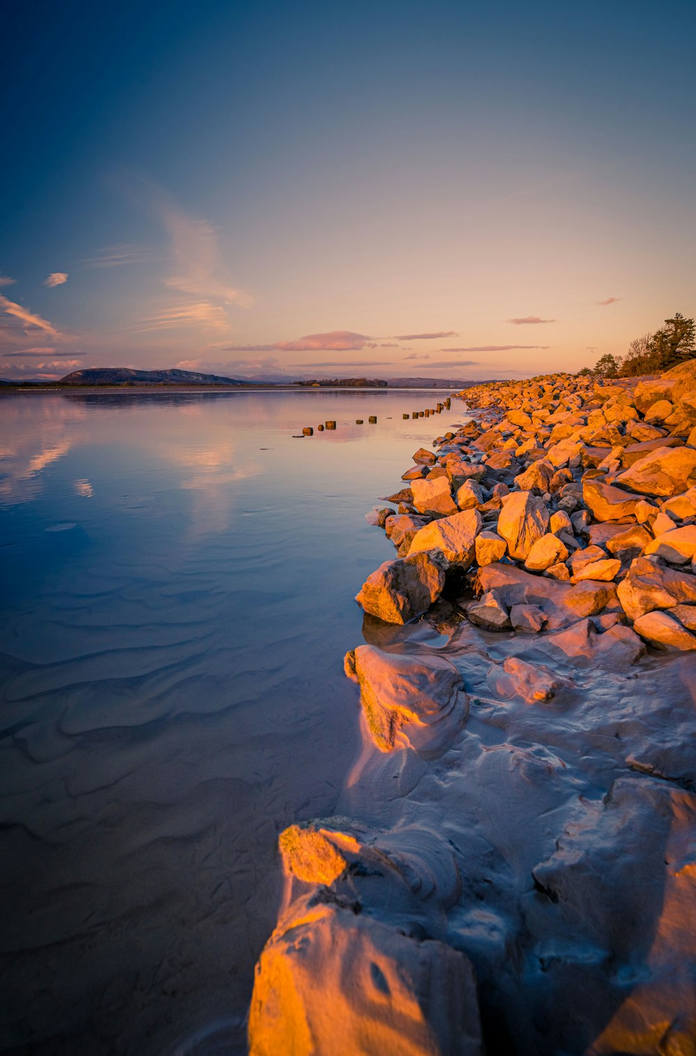 a body of water with rocks and trees around it