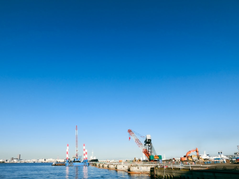 a bridge with cranes and a body of water