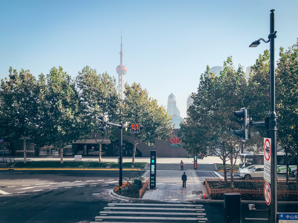 a street with trees and a tower in the background