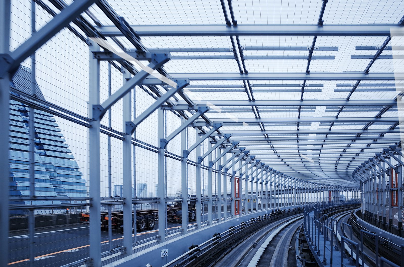 The elevated Yurikamome line running under a long glass and steel canopy in Tokyo