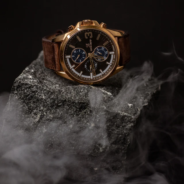 A wristwatch resting on top of a rock outdoors