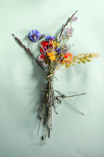 A delicate, hand-tied bouquet bursting with seasonal wildflowers in soft pastel hues.