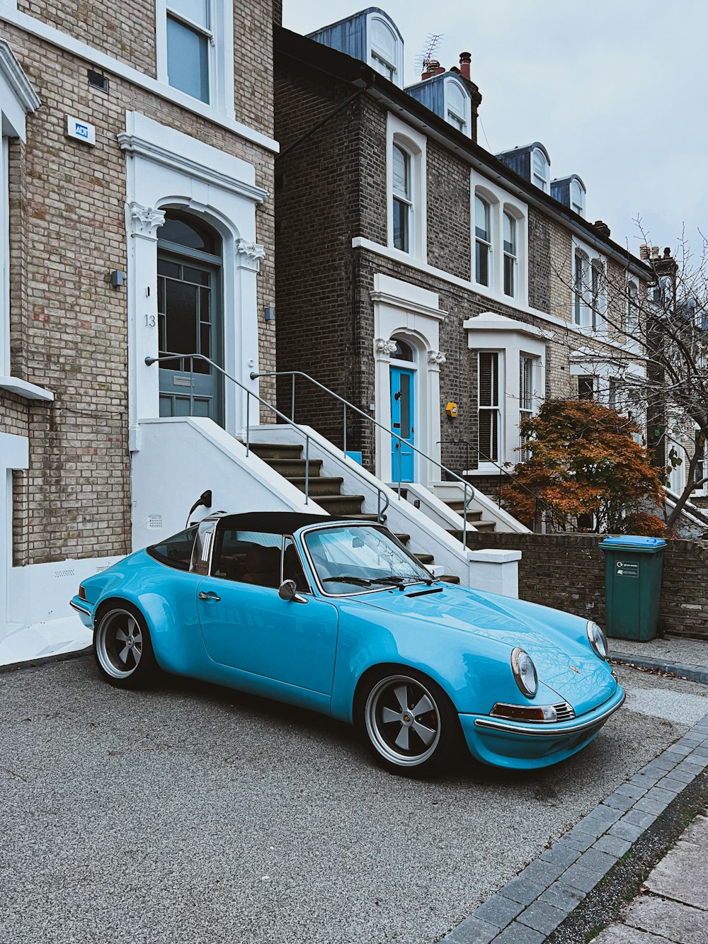 a blue car parked in front of a brick building