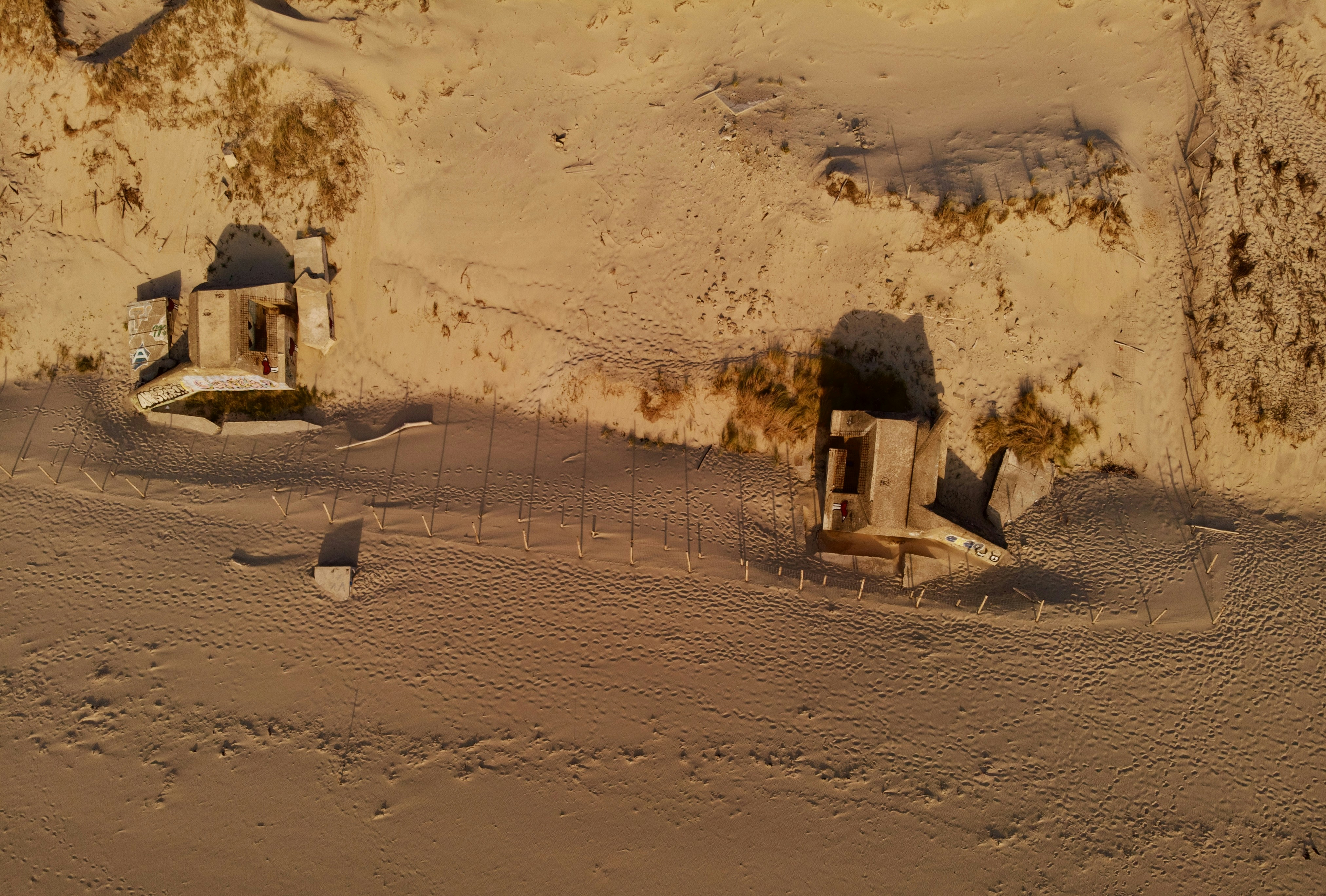 a stone building with a fence and a dirt road