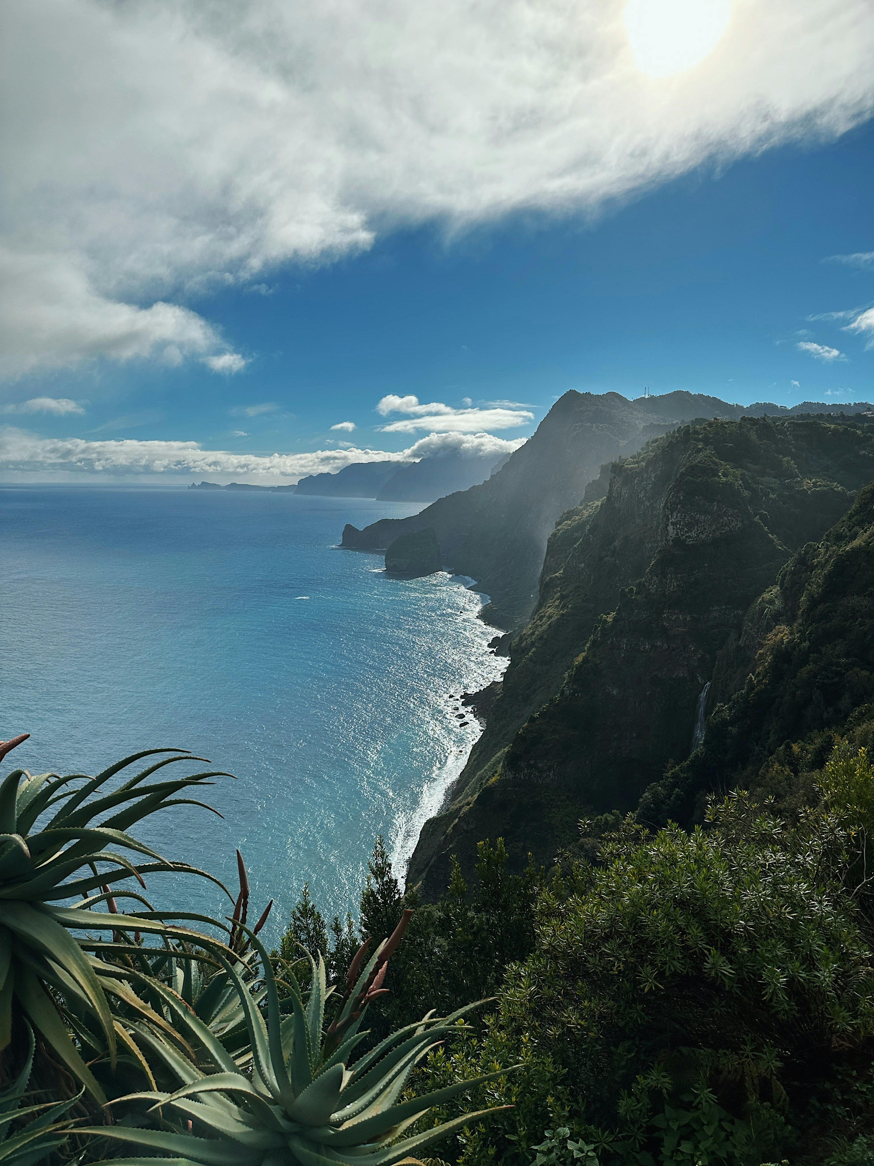 a body of water with a rocky shoreline and a large cliff with a large body of water below