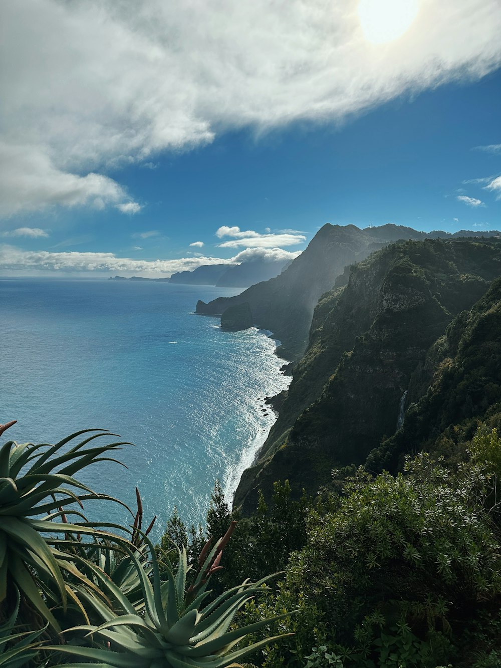 a body of water with a rocky shoreline and a large cliff with a large body of water below