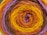 A close-up view of a rolled-up skein of yarn featuring concentric rings of different colors. The yarn is tightly wound, showcasing a vibrant pattern with distinct layers of color.