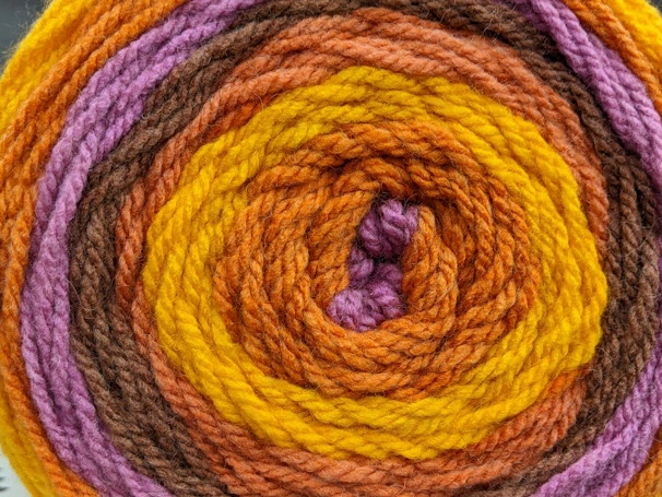 Close-up of lavender yarn transforming colors as it’s being knitted.