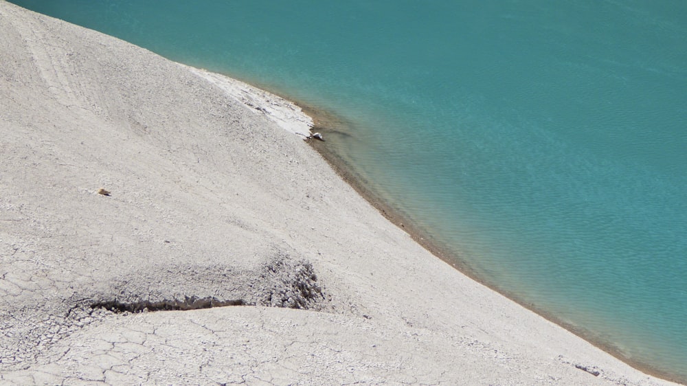 a sandy beach with a body of water in the background