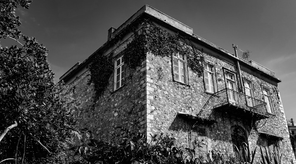a black and white photo of a house with trees in the front