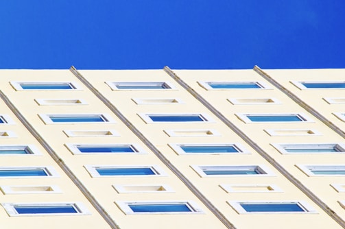 Modern white aluminum window installation on a residential building with blue sky background.