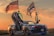 A sports car with American flag-themed decals is parked with its doors open, resembling a set of wings. Two large American flags are mounted on the back, waving in a breeze against a sunset background. The car has a sleek, modern design, emphasizing its powerful and aggressive aesthetic.