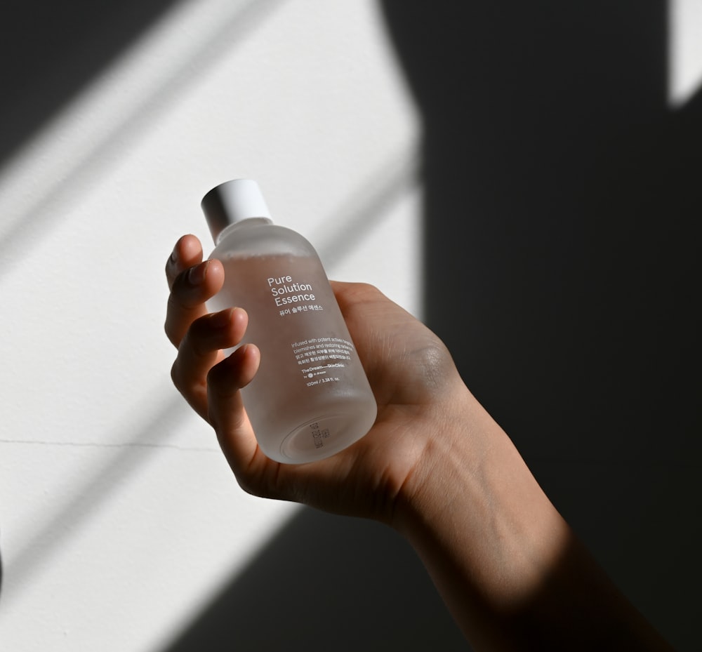 a person holding a white bottle