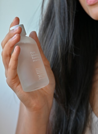 Close-up of a man applying a natural hair serum from kavo, showing the texture and clarity of the product.