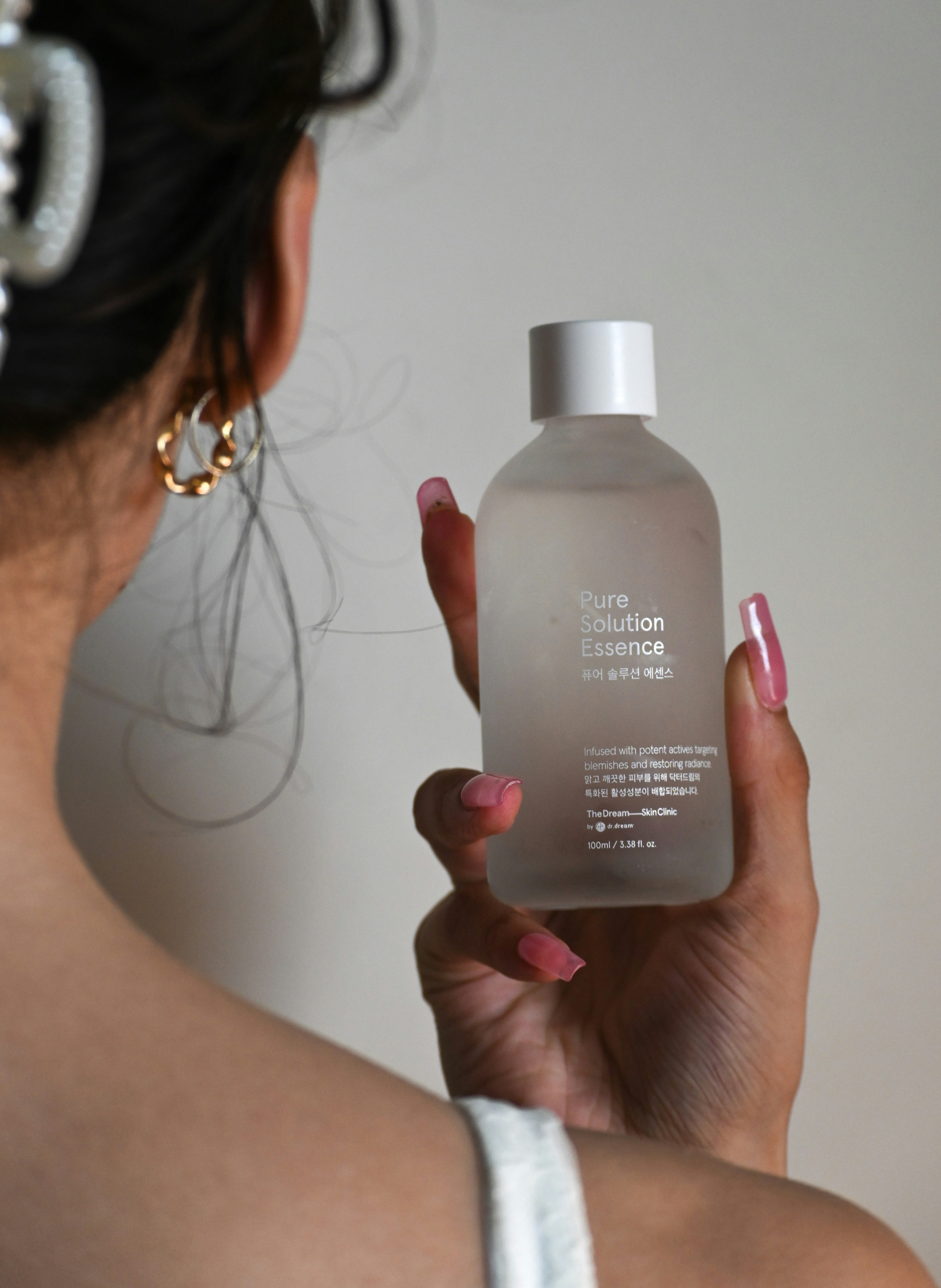 a woman holding a bottle of perfume