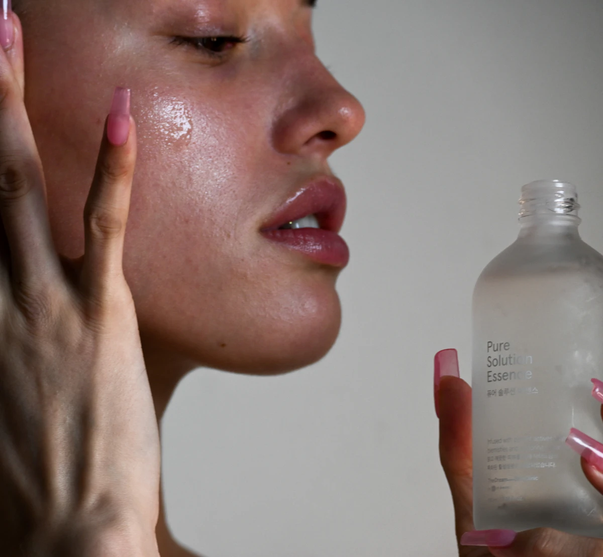Person holding a skin care serum bottle