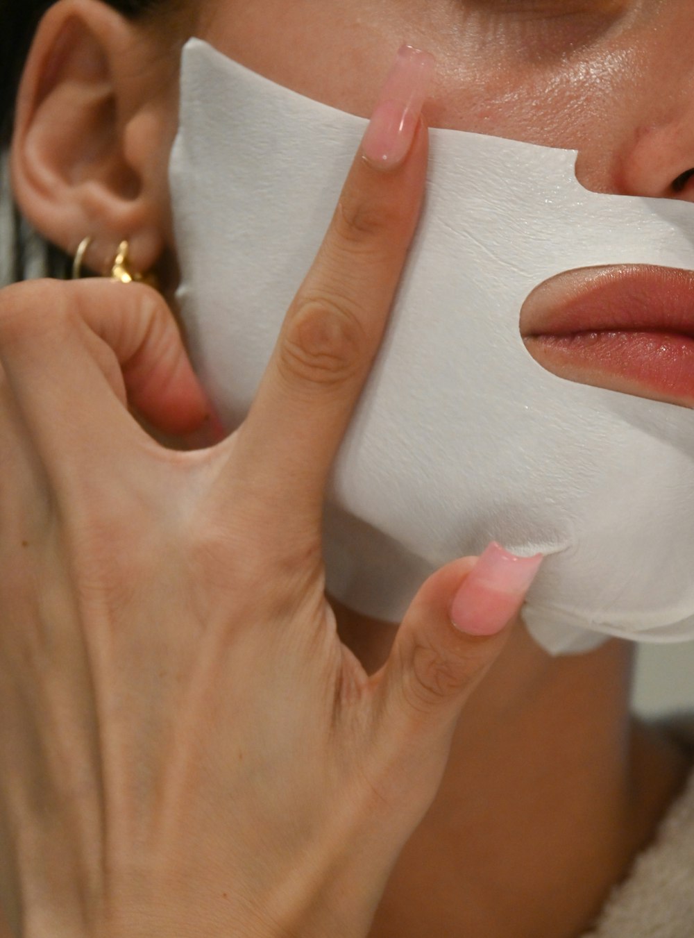 a woman putting a sheet of paper on her face