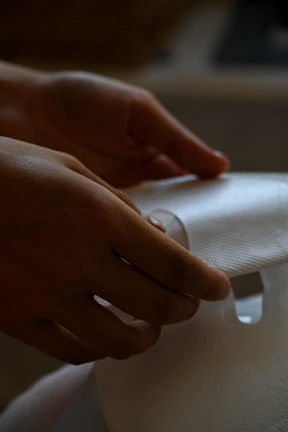 Close-up of hands gently adjusting a Pilates mat, highlighting imperfect textures.