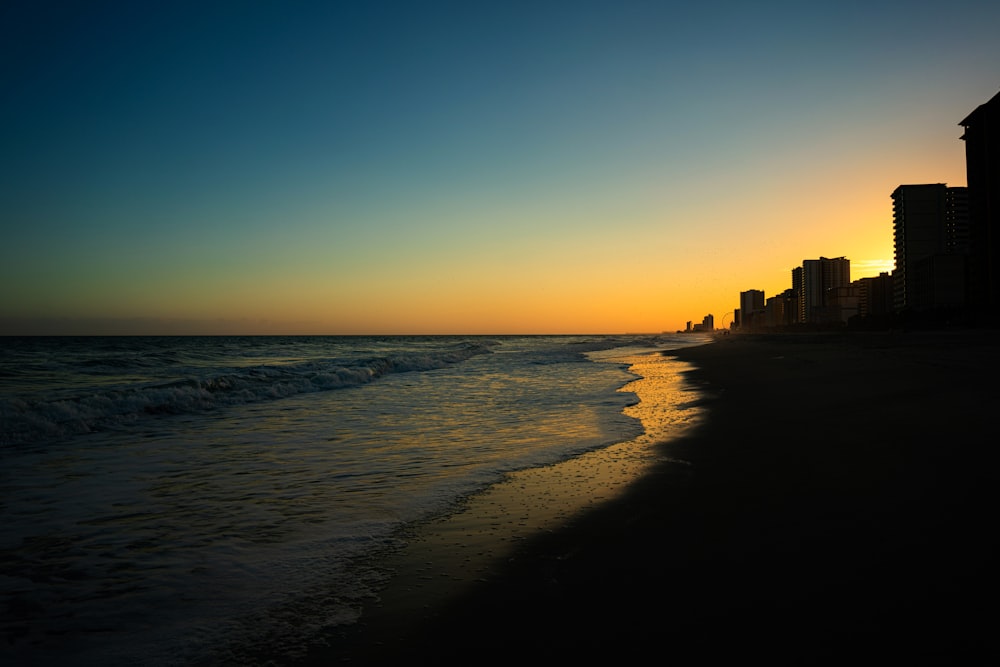 a beach with buildings and water