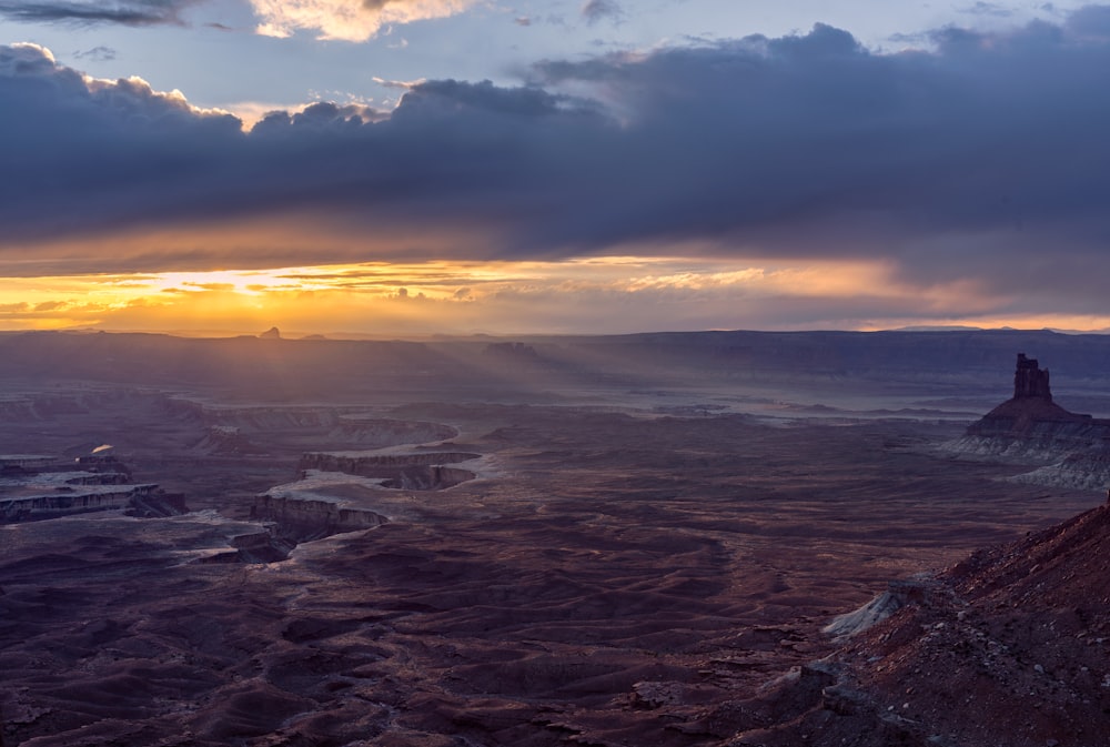 a landscape with a body of water and a rock formation in the distance