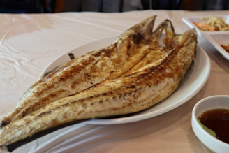 Grilled fish served with tropical sides on a rustic wooden table.