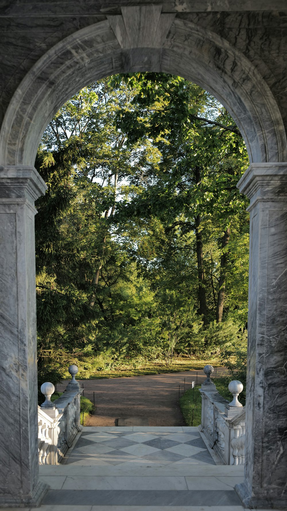 a stone walkway with trees on either side of it