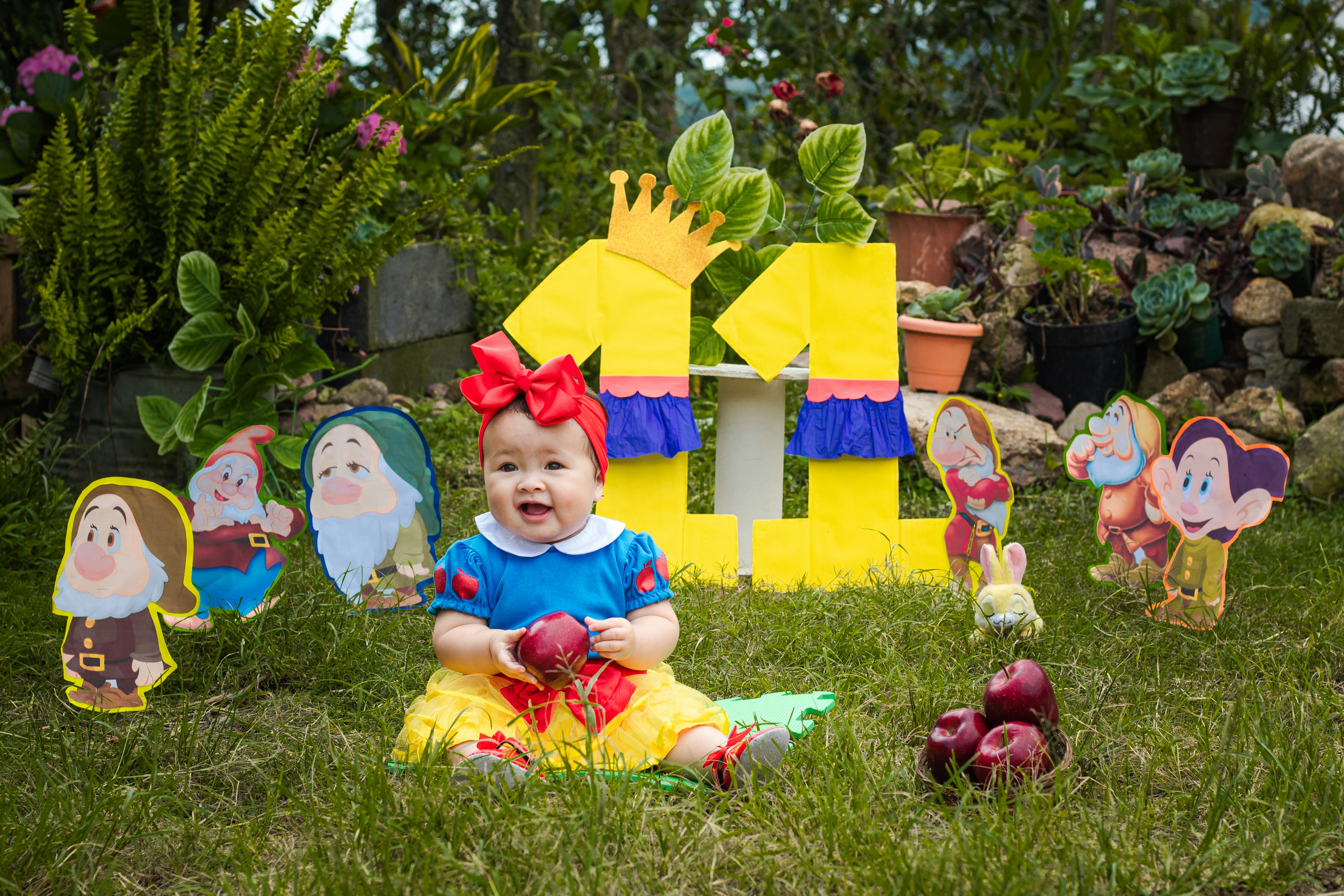 a child sitting in the grass with a group of gnomes