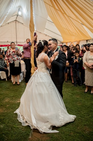 A behind-the-scenes glimpse of a videographer filming a couple’s first dance at a reception.