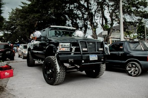 A GMC truck parked with a big red bow on the hood, ready for its new owner
