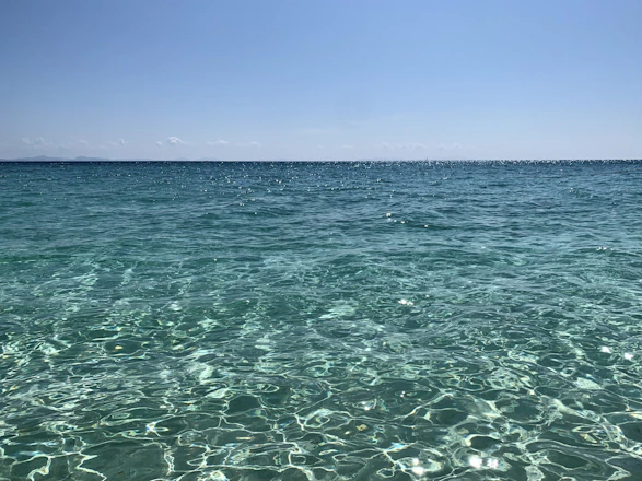 A serene view of Sumba's turquoise sea with gentle waves under a bright sky.