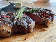 An elegant plating of a steak sliced to reveal a juicy pink center, garnished with fresh rosemary.