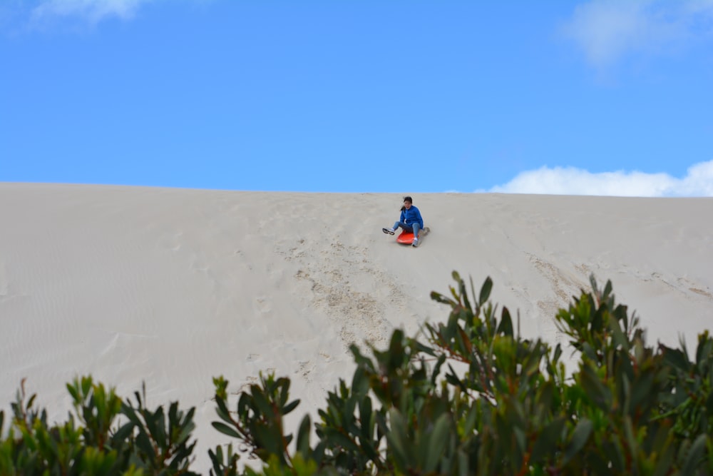 a person riding a sled in the sand