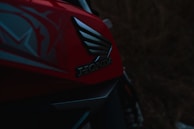 A dynamic shot of a glossy Honda scooter angled to showcase its modern design and red accents.