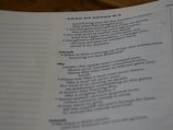 A close-up view of a page from a book, featuring text from the Bible, specifically Song of Songs 8:3. The text is presented in a structured format, with section headings such as 'Friends' and 'She'. The focus is mainly on the center and right side of the page.