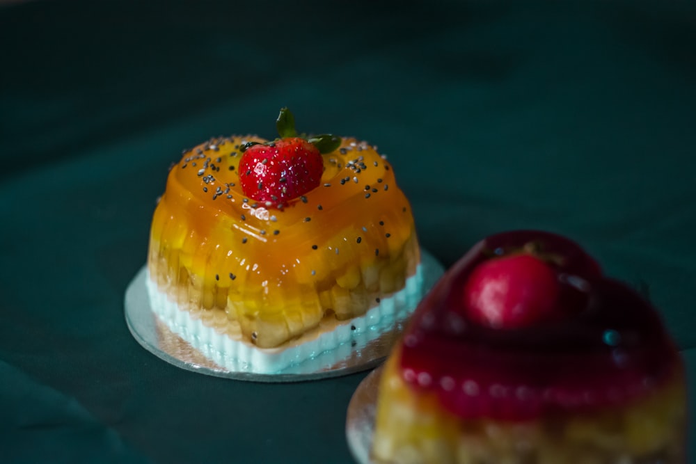 a couple of desserts with fruit on top