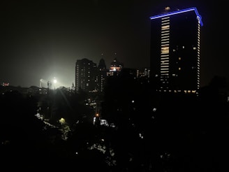 A nighttime cityscape used as a backdrop for an outdoor film shoot under soft blue lighting.