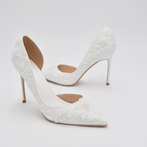 Elegant white high-heeled shoes featuring intricate floral lace details and a pointed toe design.