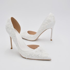 Elegant white high-heeled shoes featuring intricate floral lace details and a pointed toe design.