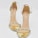 A pair of elegant high-heeled sandals designed with golden metallic bands and adorned with sparkling gemstone embellishments across the toes. The ankle strap is thin and has a buckle, providing additional support and style.