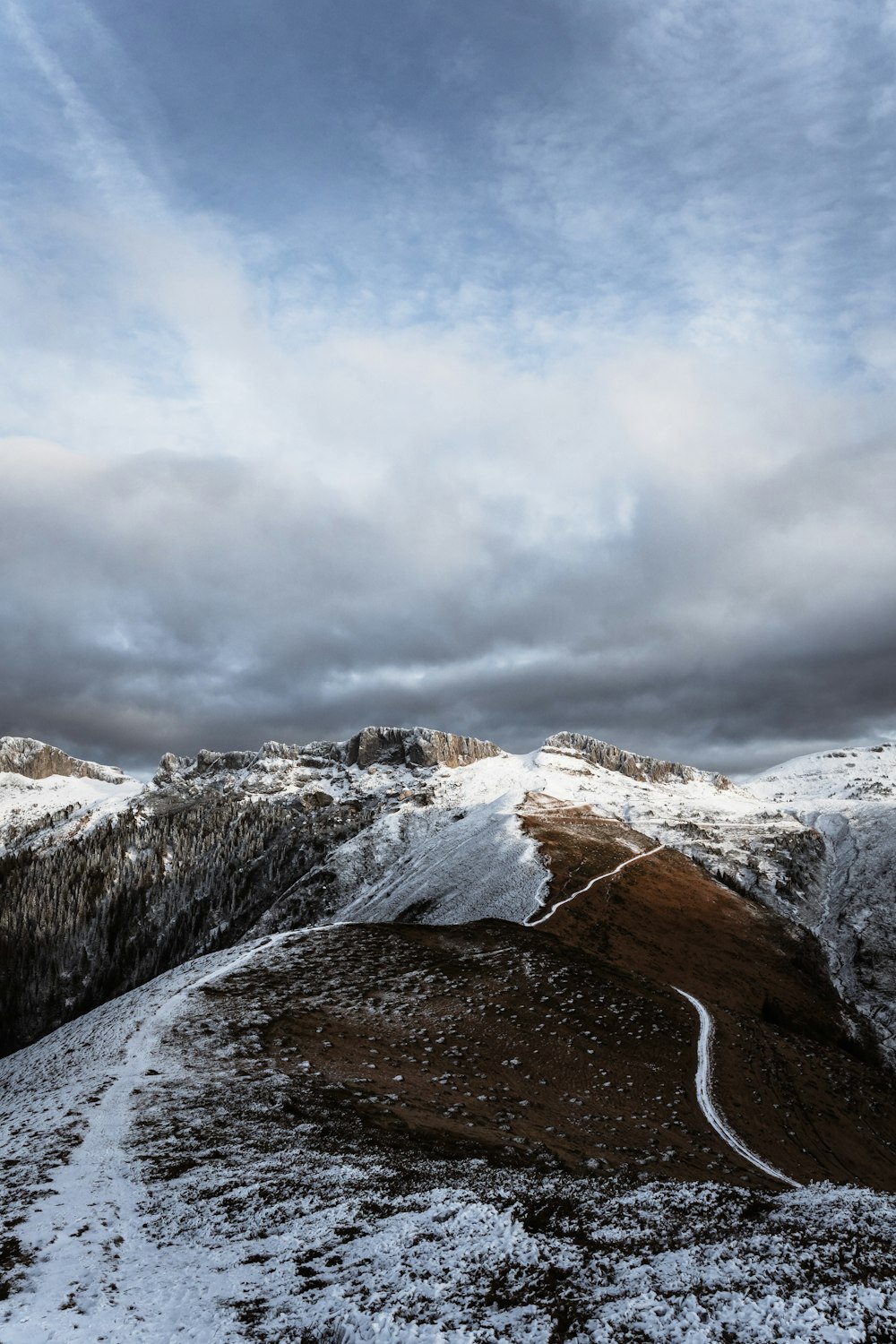 a snowy mountain with a stream running through it