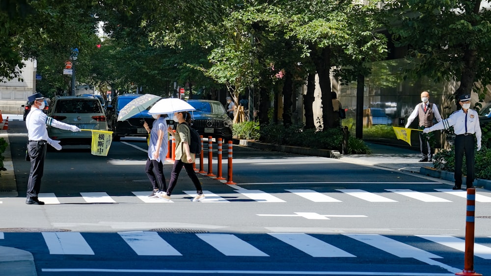 a group of people walk across a crosswalk