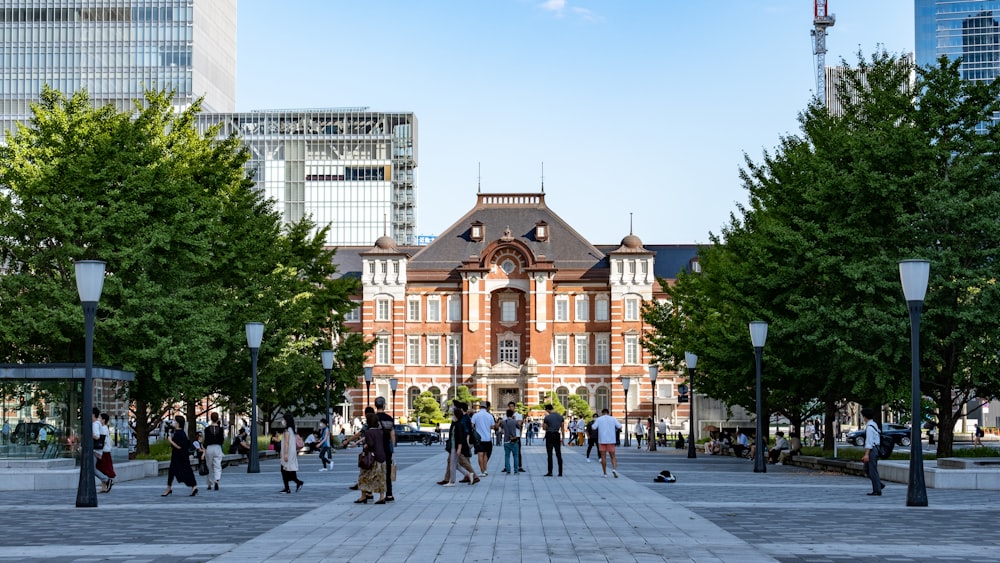 a group of people walking on a street in front of a building