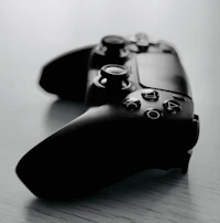 An artistic shot of a game controller resting on a desk with Zerosoftgames artwork in the background.