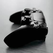 Close-up of PlayStation 5 controllers resting on a sleek gaming table.
