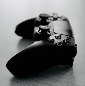 Close-up of PlayStation 5 controllers resting on a sleek gaming table.